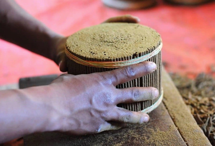 Hands actively pressing and shaping incense dough, capturing the handmade process and traditional craftsmanship behind Nepalese incense making.